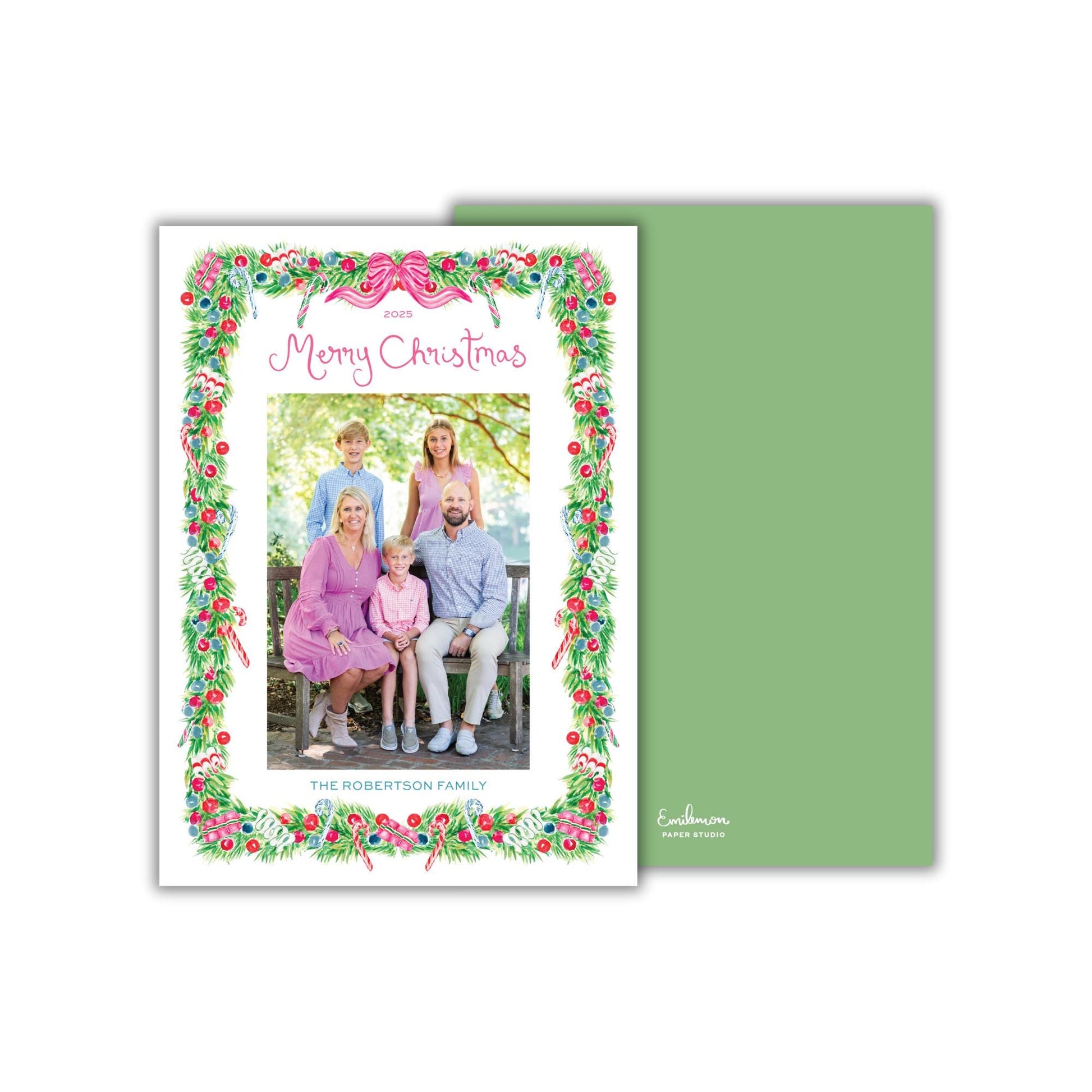 A family portrait of a group of people, likely a family, with a festive wreath border surrounding the image.