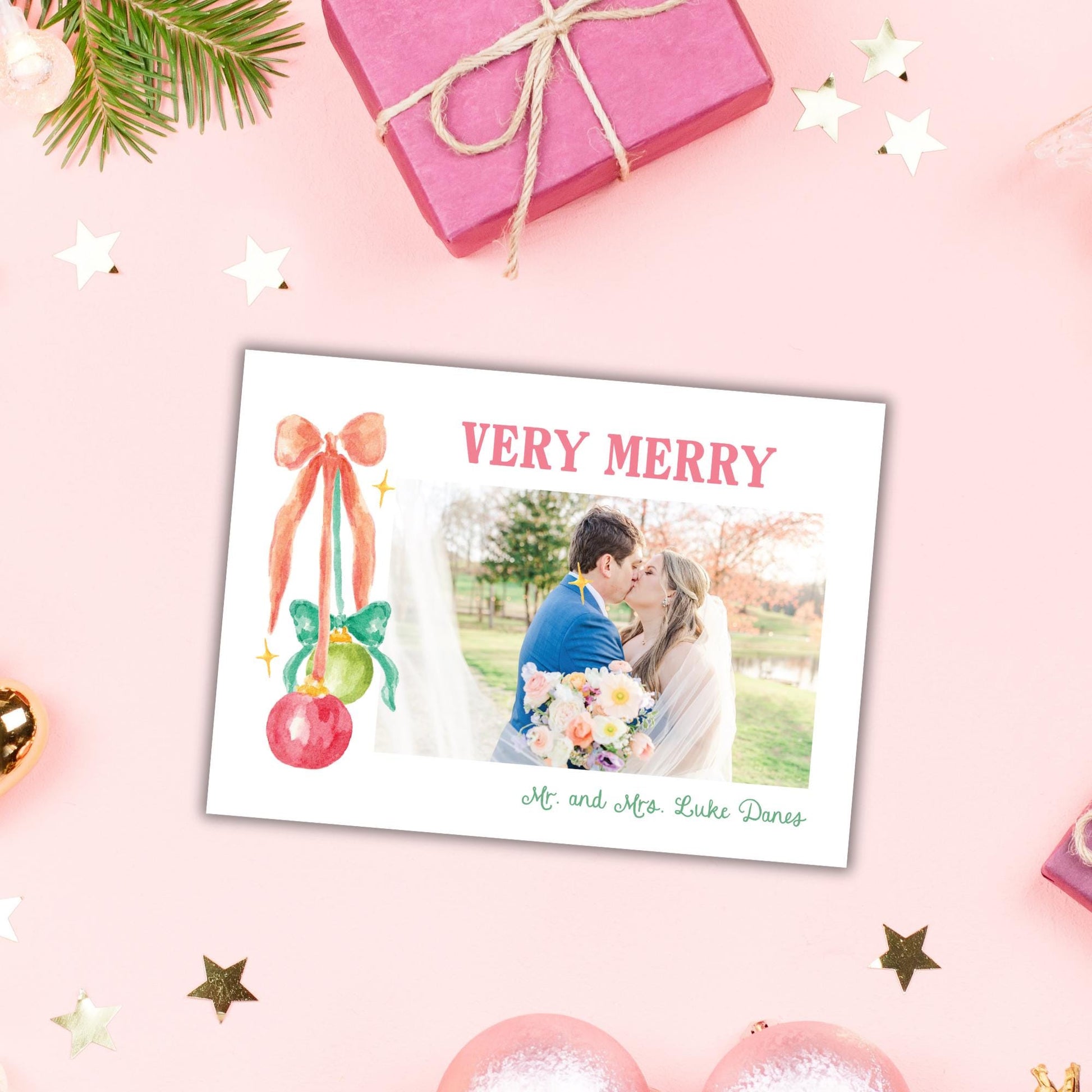 A pink gift box with a bow, a couple embracing, and a photo of the couple is displayed on a pink background with Christmas ornaments and stars.