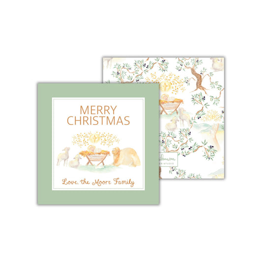 The image is a Christmas card featuring a nativity scene with a baby Jesus, sheep, and dogs. The card has a green background with the text "Merry Christmas" and "Love the Moore Family" written on it.