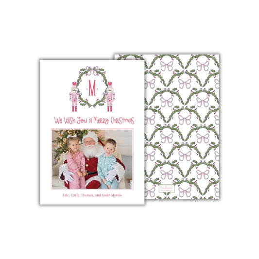 A Christmas card featuring a photo of a family with Santa Claus, and a repeating pattern of holly leaves and butterflies on the background.