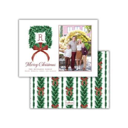 A Christmas card featuring a family photo and a wreath with a letter "R" on it.