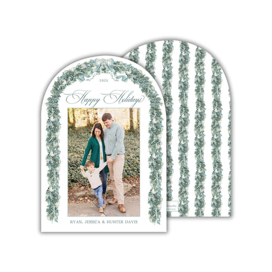 A 2015 holiday greeting card featuring a family photo of a man, woman, and child standing together in a garden setting.