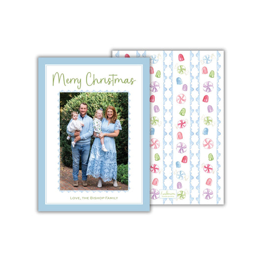 A family portrait of a man, woman, and child standing together in front of a natural backdrop, with a patterned background featuring colorful flowers.