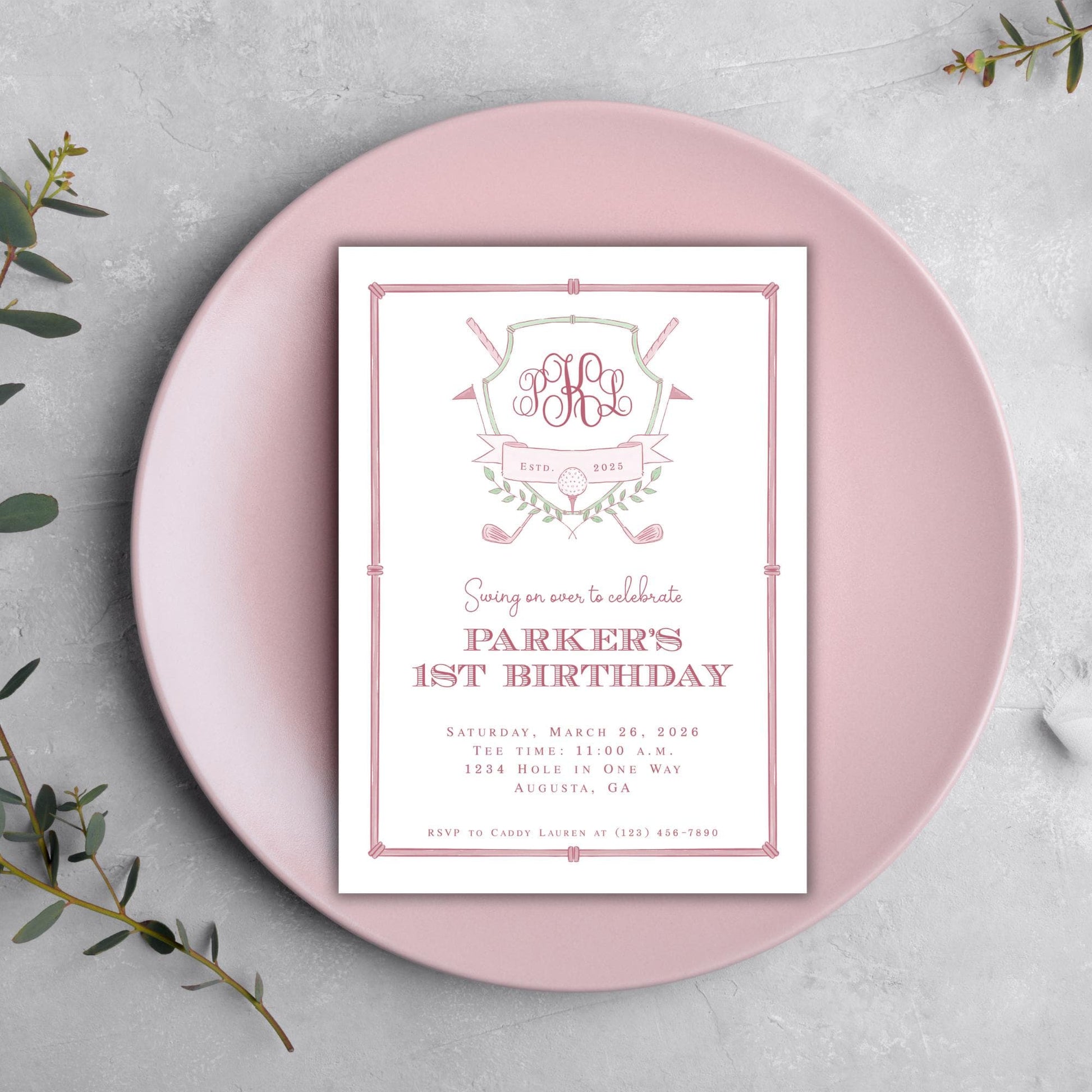 A pink invitation card for a Parker's 1st birthday celebration, featuring a monogrammed logo and text.