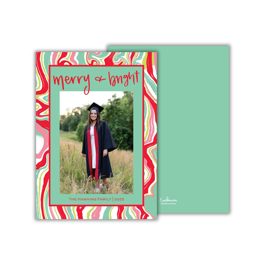 a young woman in a graduation gown standing in a field of tall grass.