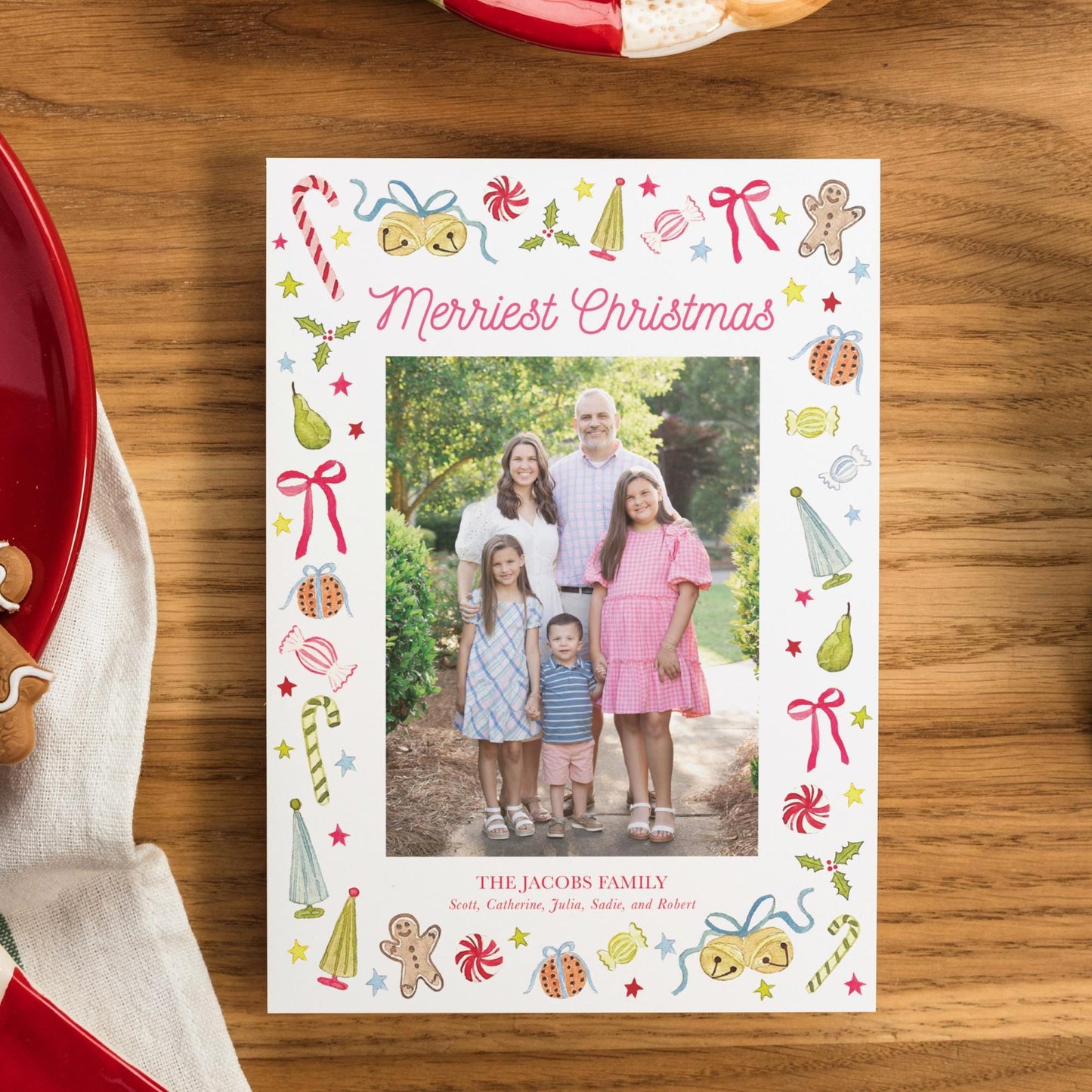 A family portrait of a group of people, including a man, a woman, and two children, is displayed on a white card with a festive border.