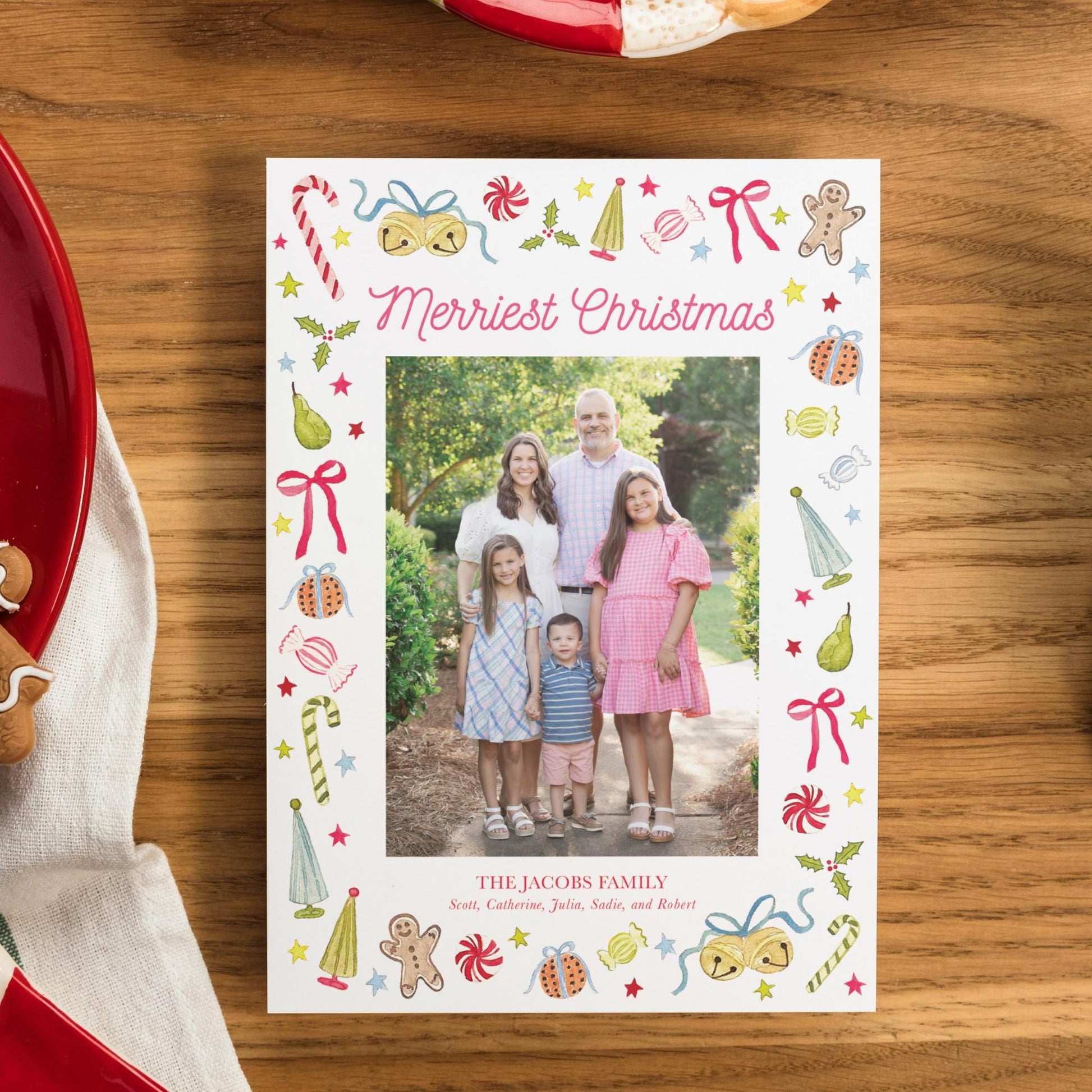 A family portrait of a group of people, including a man, a woman, and two children, is displayed on a white card with a festive border.