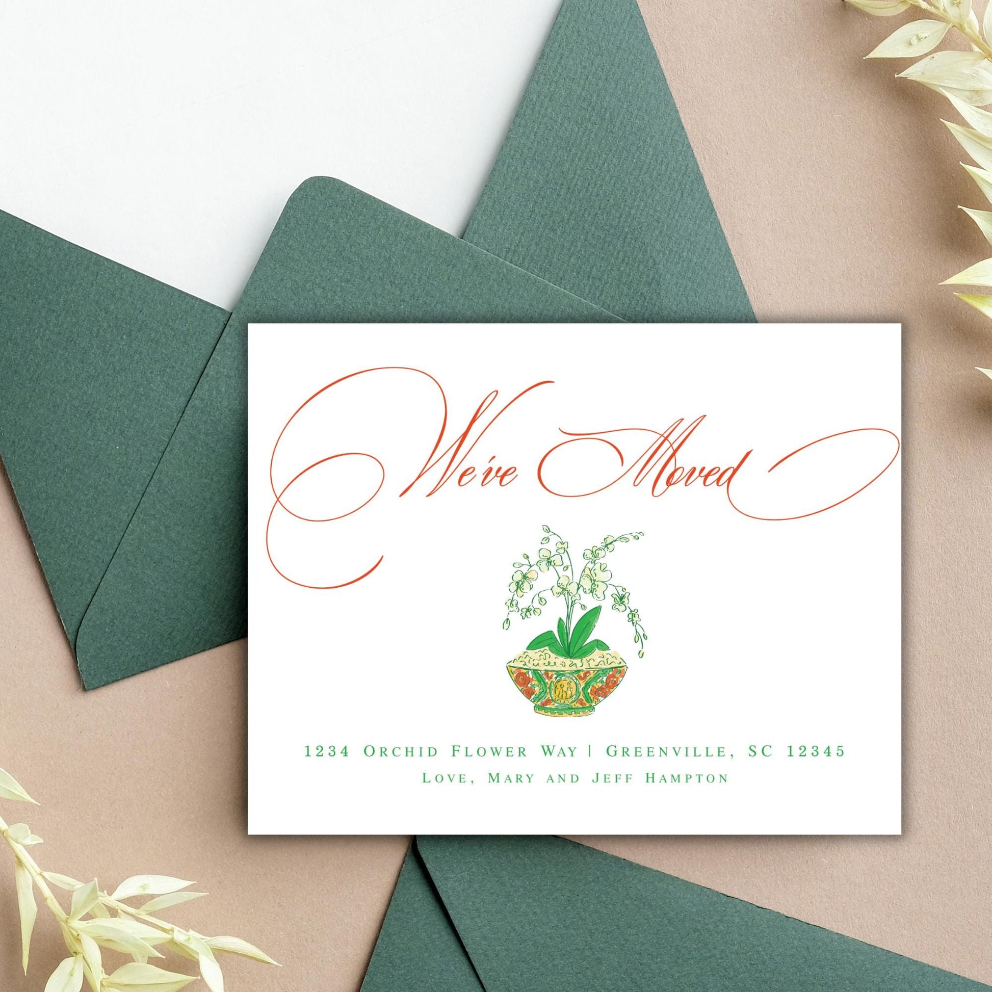 The image is a white envelope with a green envelope placed on top of it, both containing a red cursive message that reads "We've moved" and an illustration of a lily of the valley plant.