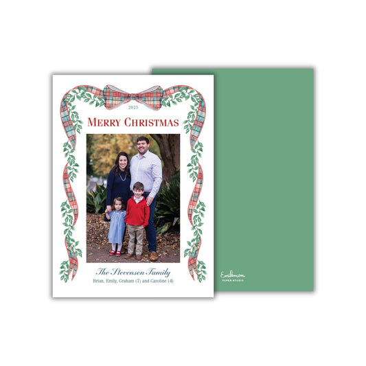 A family portrait of a man, woman, and two children, with a festive plaid border and a green card behind it.
