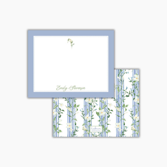 a blue and white floral patterned card with a blank white card frame on top of it.