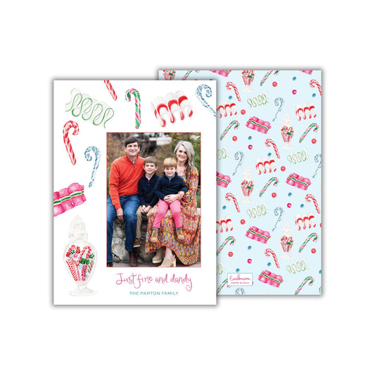 A family portrait of a man, woman, and two children, with a background featuring various Christmas-themed elements such as candy canes, snowflakes, and a jar of candy.