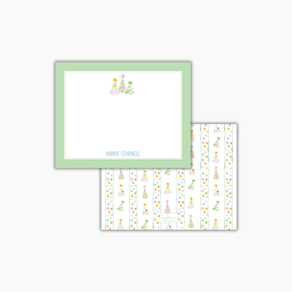 The image is a green-framed note card with a white background and a pattern of colorful Christmas trees on it.