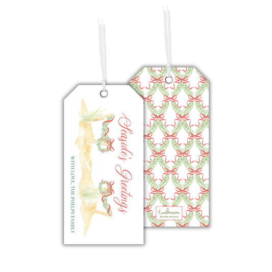 two tags with Christmas-themed designs hanging from strings.