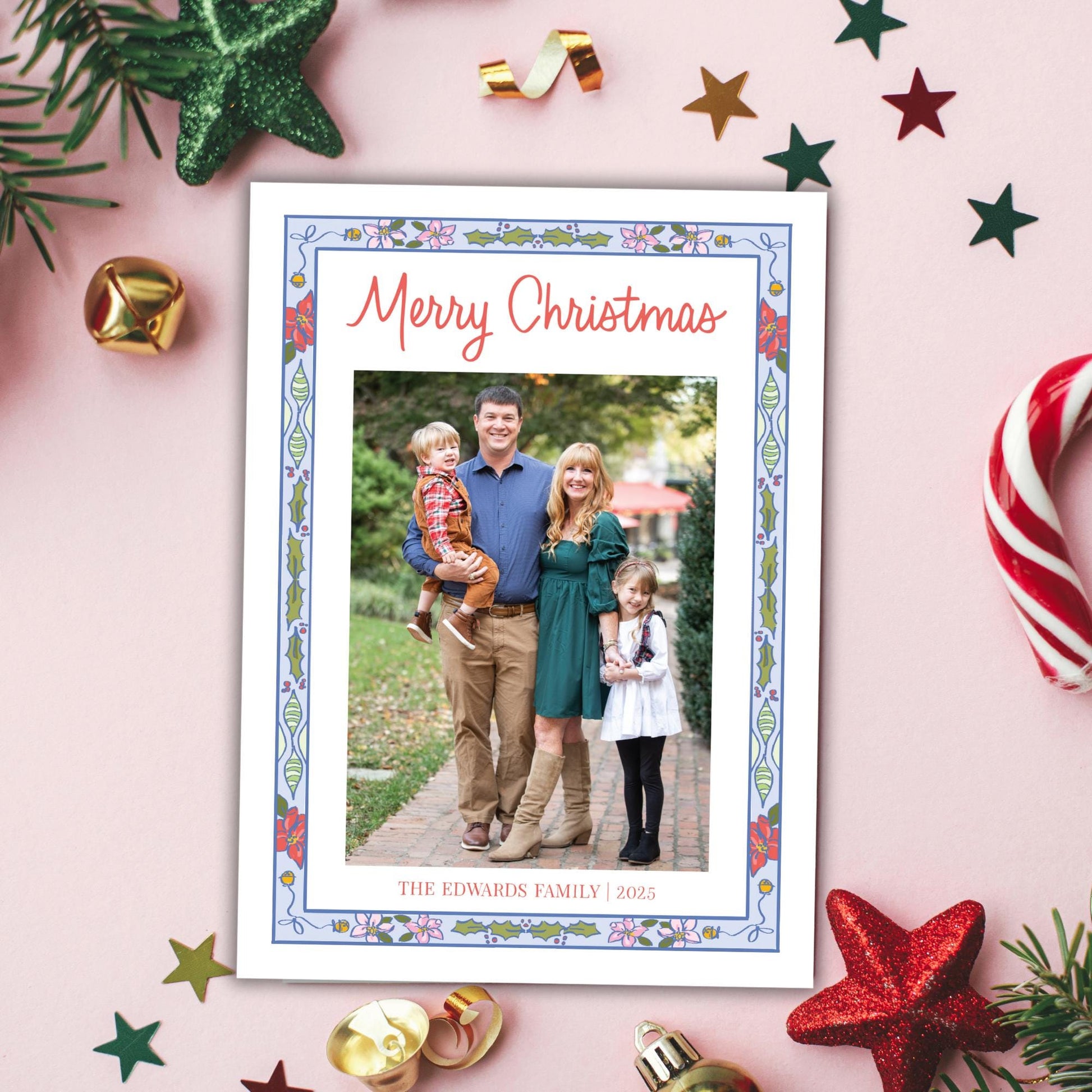 A family portrait of a man, woman, and two children, surrounded by Christmas decorations such as stars, candy canes, and ornaments.