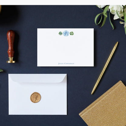 a collection of stationery items, including a white envelope with a gold seal, a gold pen, a gold stapler, and a gold notebook, all arranged on a dark blue background.