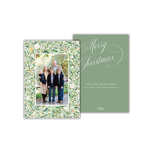 A family portrait of a group of people, including a man, a woman, and several children, is displayed on a green card with a floral pattern.