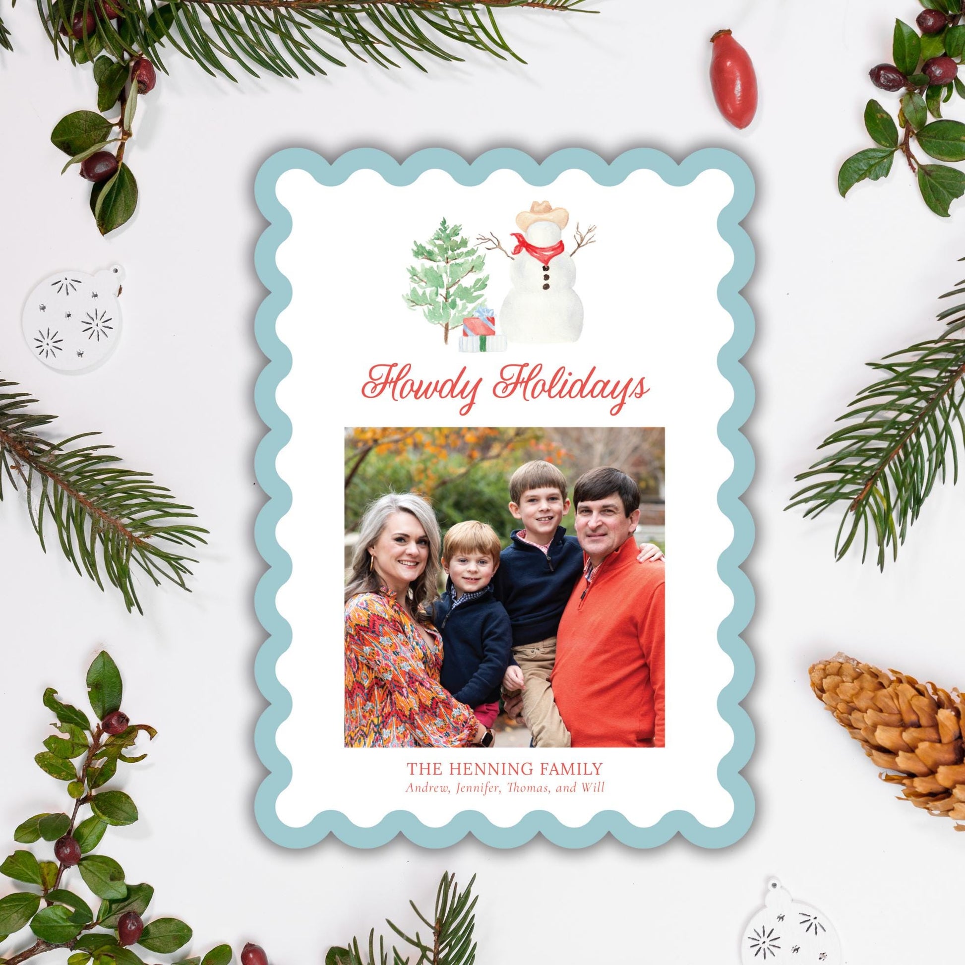A family portrait of a woman, a man, and two children, surrounded by holiday decorations such as pine branches, berries, and ornaments.