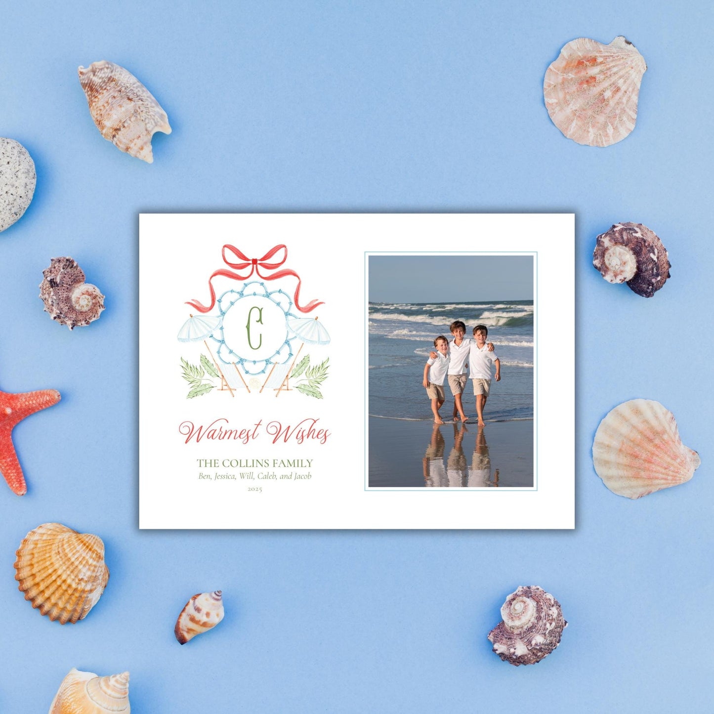 A white card with a photo of three children standing on a beach, surrounded by various seashells and starfish on a blue background.