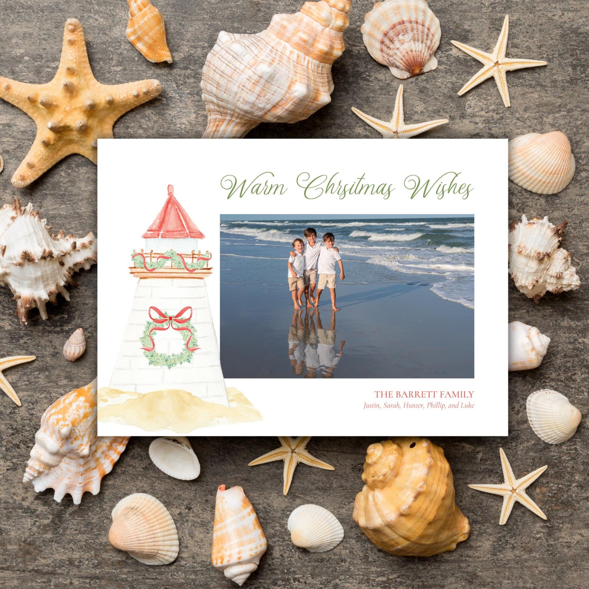 A white card with a photo of three people on the beach, surrounded by various seashells and starfish on a wooden surface.