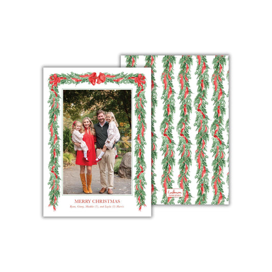 A family portrait of a man, woman, and two young girls, surrounded by a festive wreath design. The text &quot;MERRY CHRISTMAS&quot; is displayed below the family photo, and the phrase &quot;Riley, Grace, Middle, 7, and Lyla Harris&quot; is written on the back of the card.