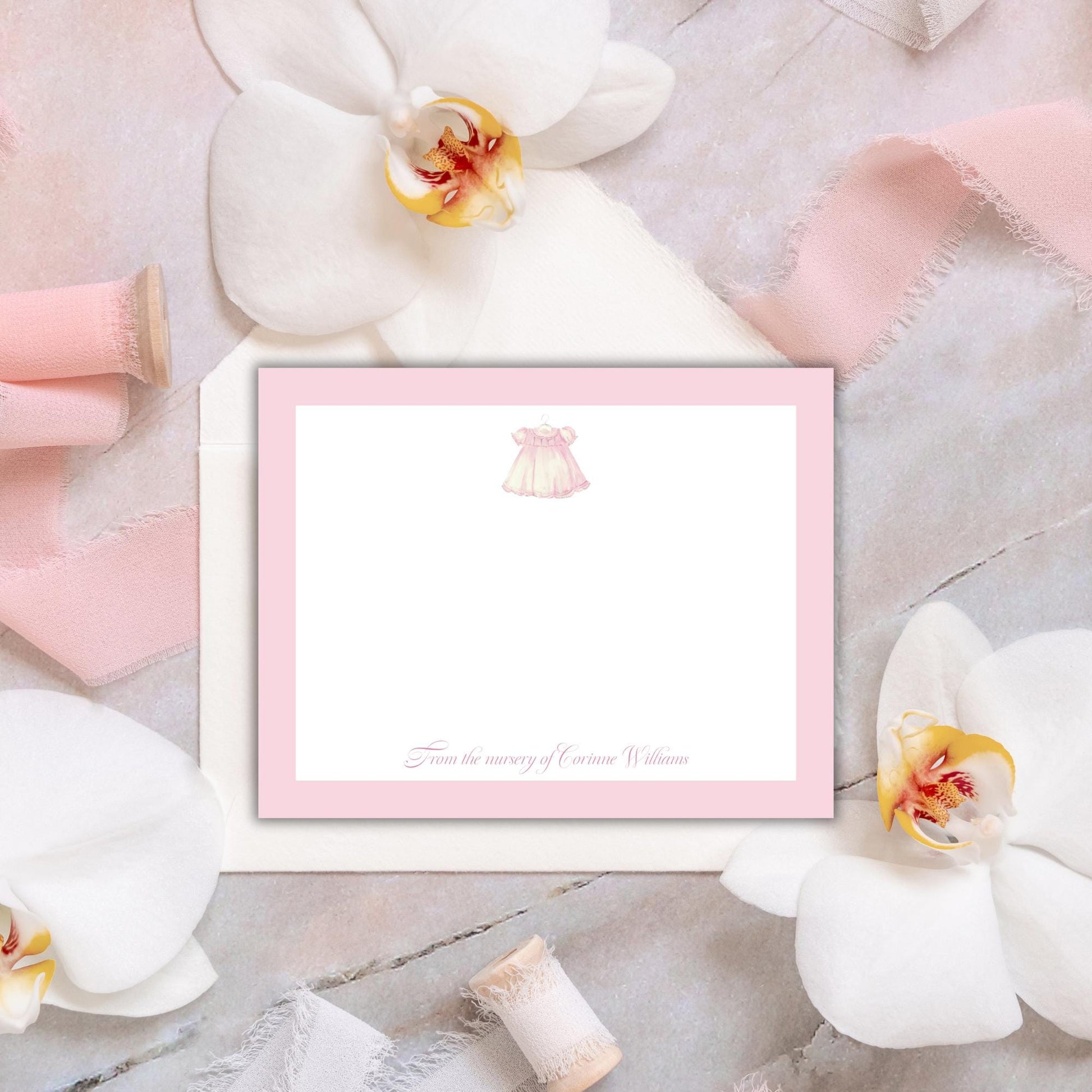 a pink and white card with a blank space in the center, surrounded by various decorative elements such as white flowers, pink ribbons, and a lace doily.