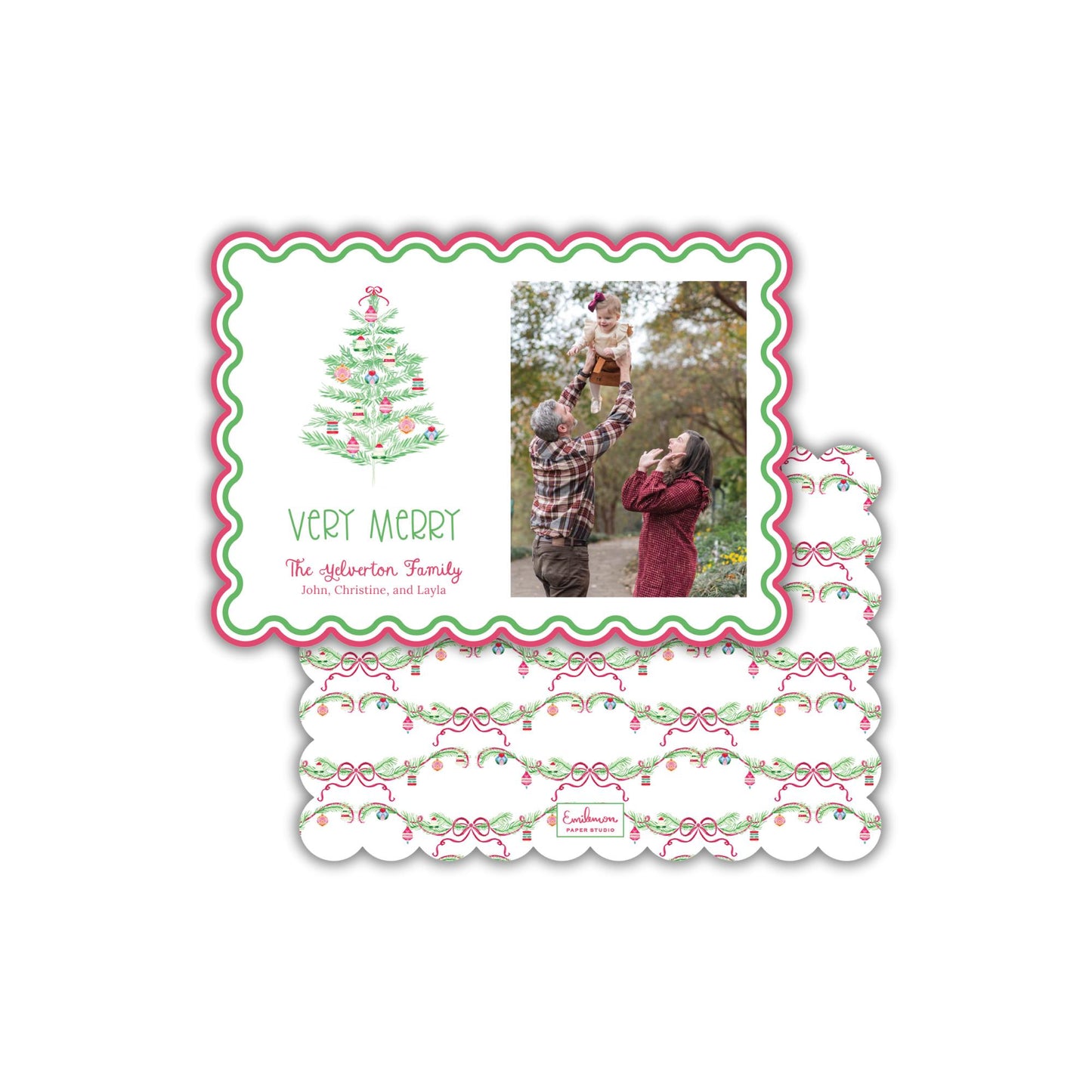 A Christmas card with a photo of a family, including a man, a woman, and a child, along with a Christmas tree design. The card has a scalloped edge and a floral pattern.