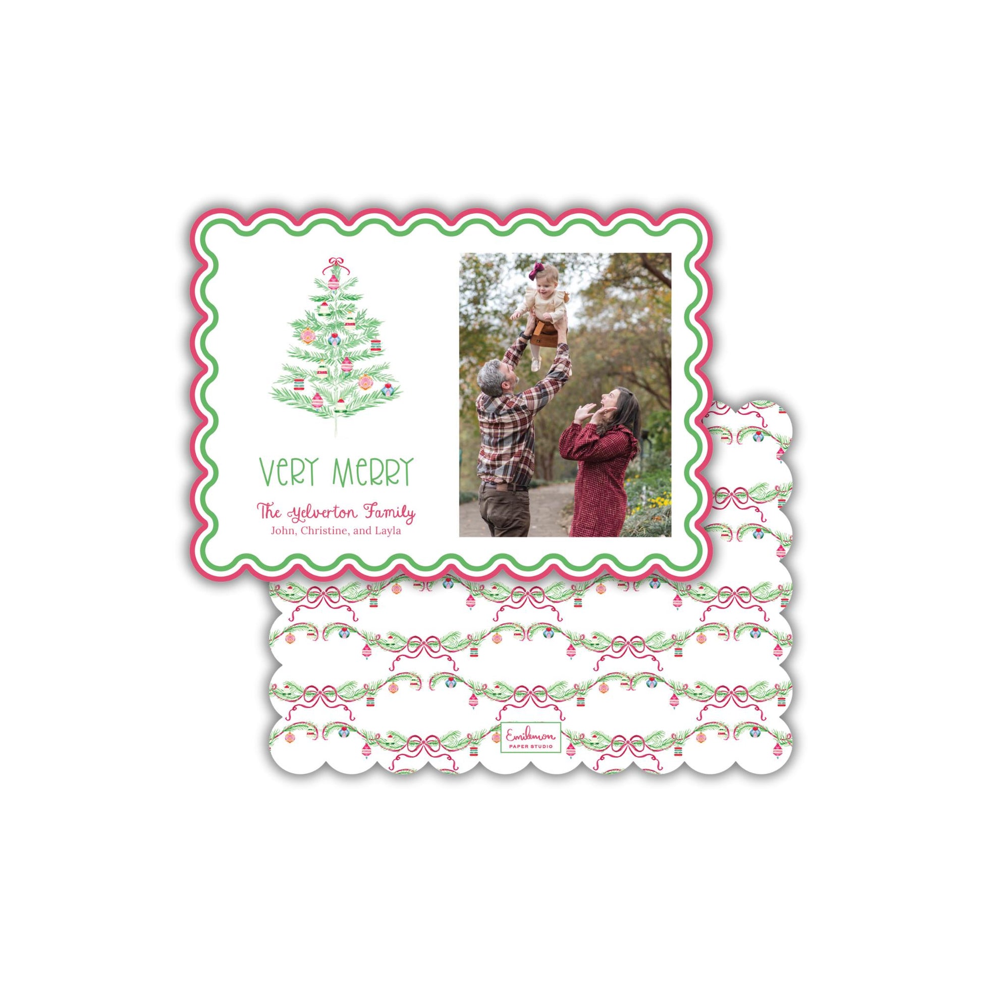 A Christmas card with a photo of a family, including a man, a woman, and a child, along with a Christmas tree design. The card has a scalloped edge and a floral pattern.