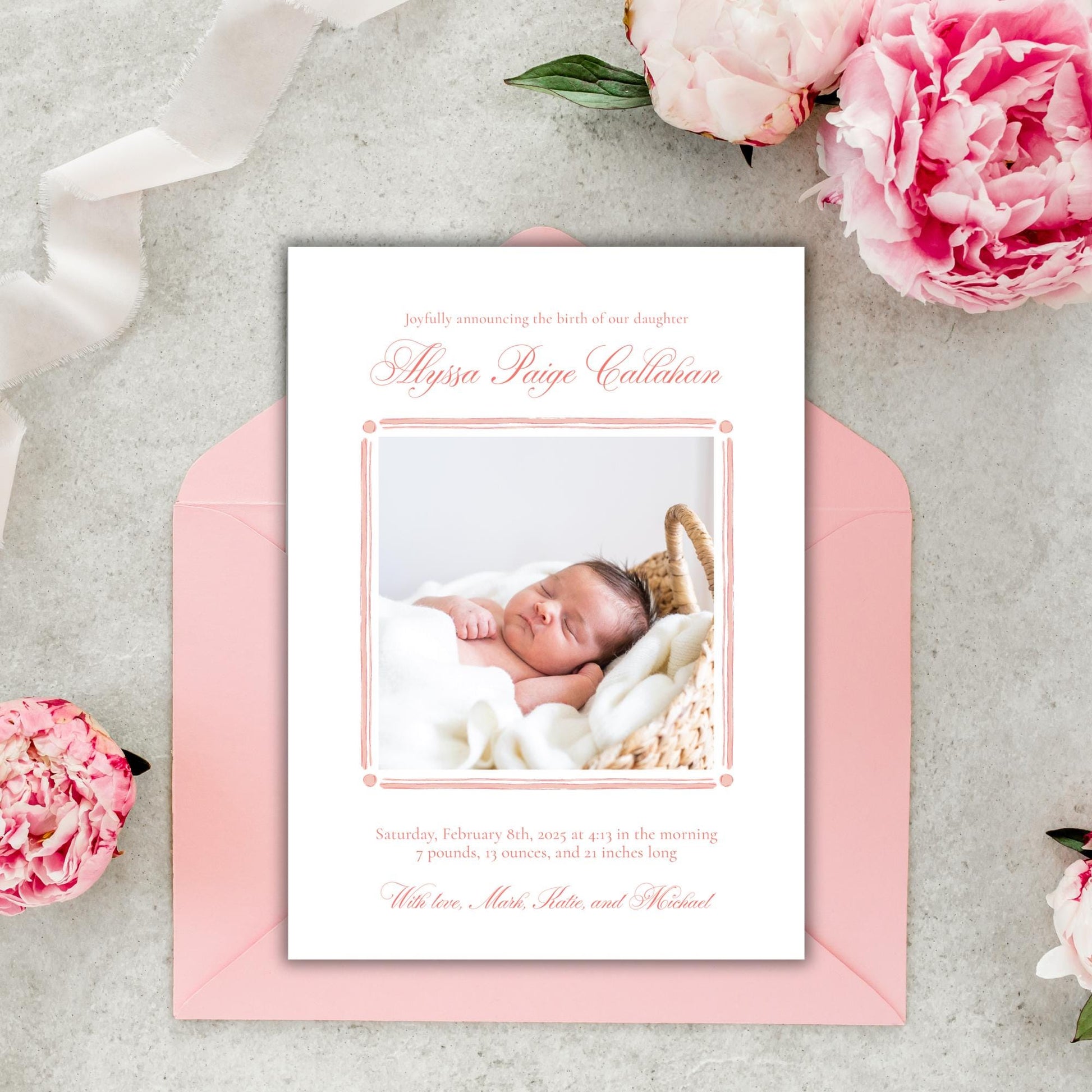 a pink envelope with a photo of a baby on it