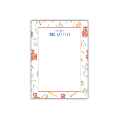 A personalized nameplate with a pattern of school supplies and a schoolhouse.