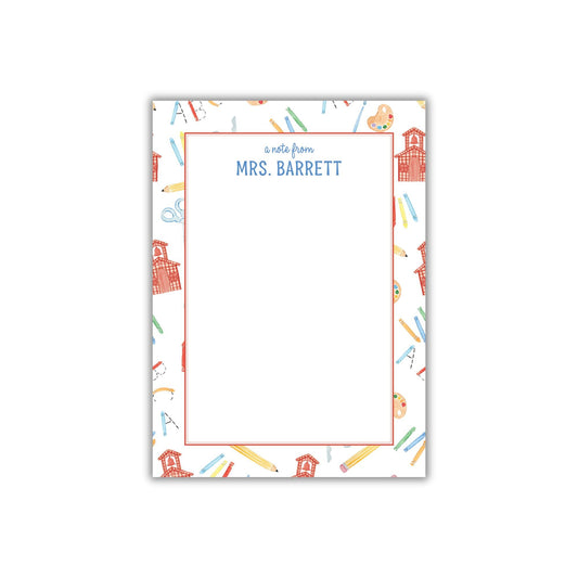 A personalized nameplate with a pattern of school supplies and a schoolhouse.