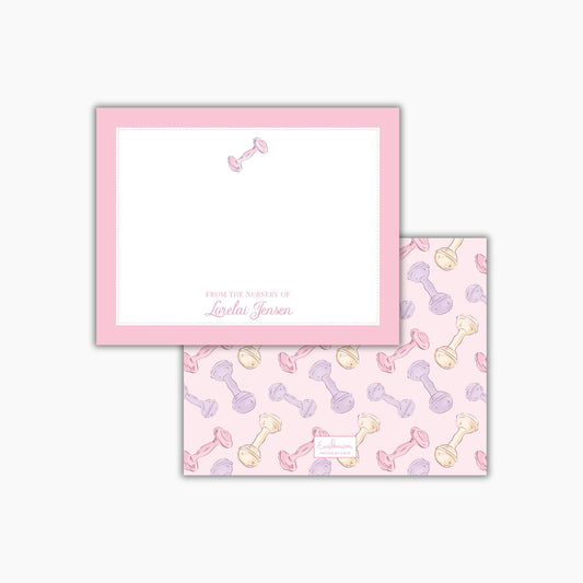 a pink frame with a blank space for writing, and a pattern of baby bottles in various colors on the back cover.