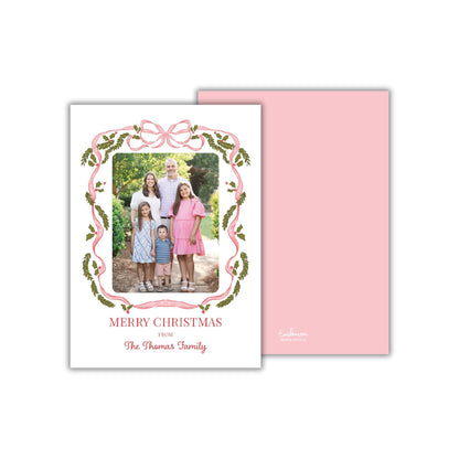 A family portrait of a group of people, likely a family, with a pink and green decorative border around the photo. The text "MERRY CHRISTMAS FROM The Thomas Family" is displayed on the card.