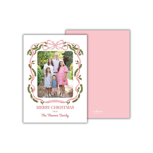 A family portrait of a group of people, likely a family, with a pink and green decorative border around the photo. The text &quot;MERRY CHRISTMAS FROM The Thomas Family&quot; is displayed on the card.
