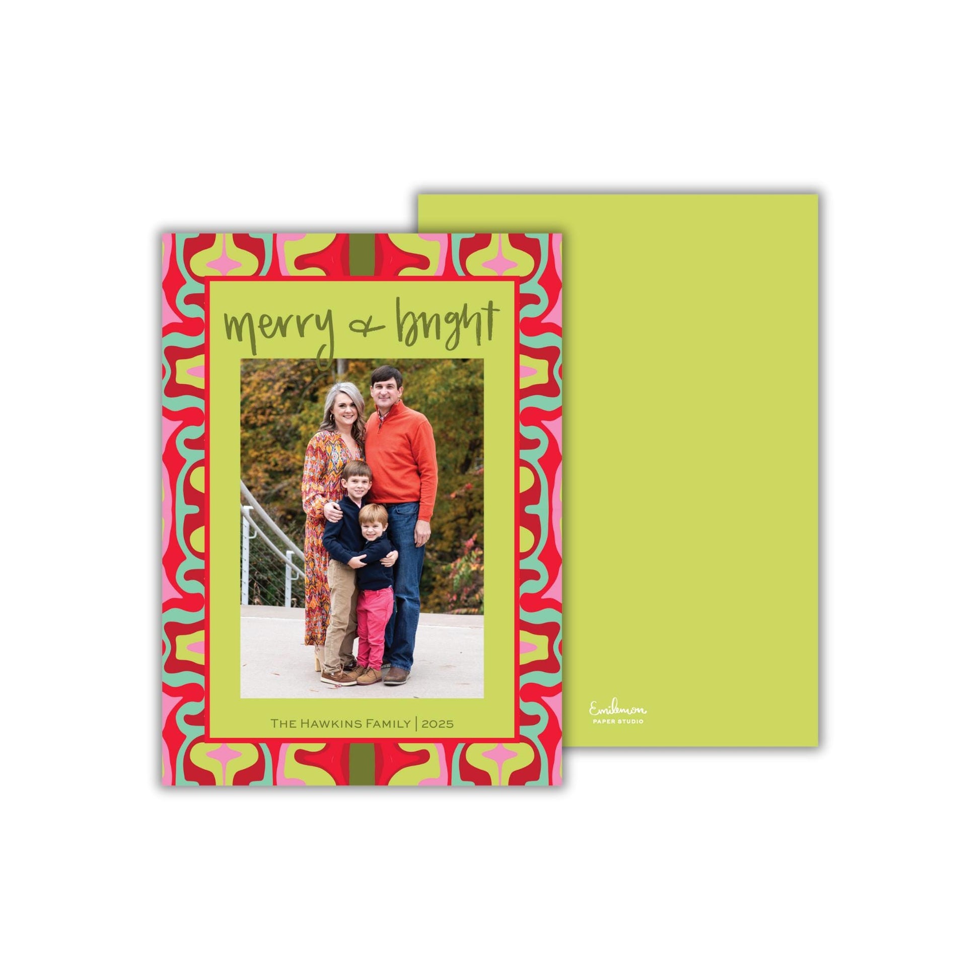 A family portrait of a man, woman, and child, with the text &quot;Merry + Bright&quot; written above the photo.