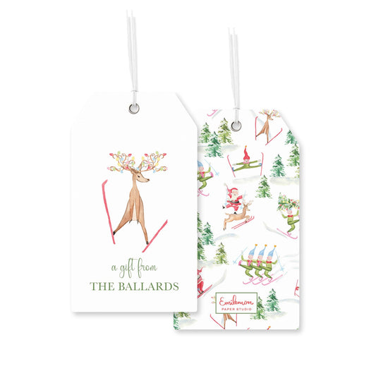 two white tags with illustrations of deer and skiers, hanging from strings.