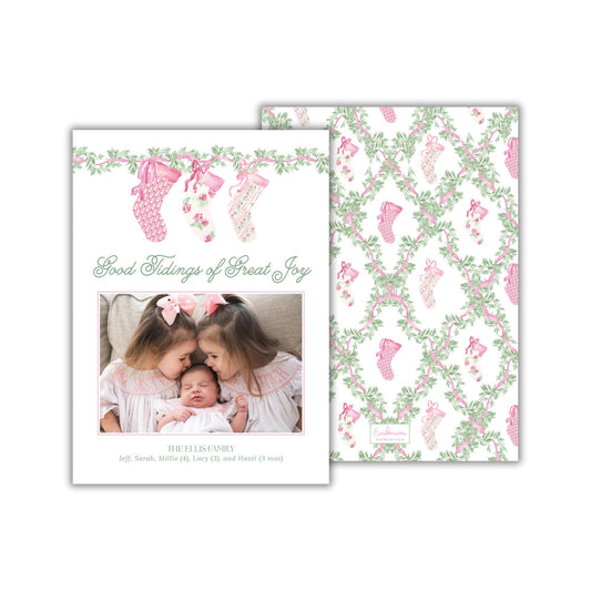 The image is a holiday-themed card featuring two young girls in pink dresses, with a baby girl in the center. The card has a floral pattern and the text &quot;Good Tidings of Great Joy&quot; and &quot;The Ellips Family&quot; printed on it.