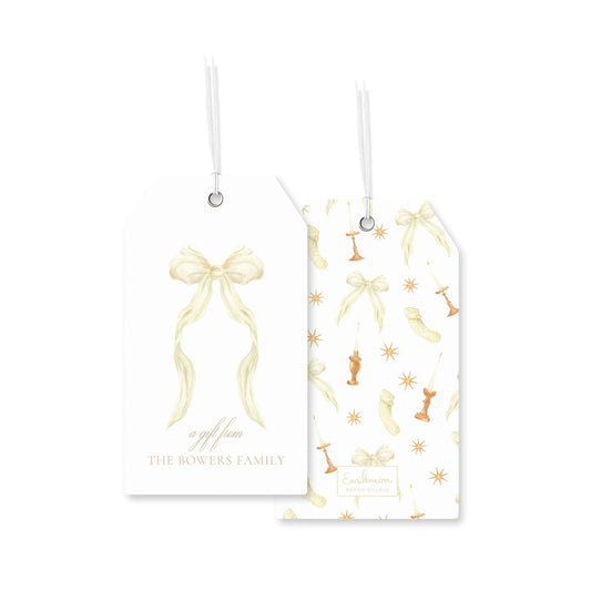 two white gift tags with gold bows and star-like designs.