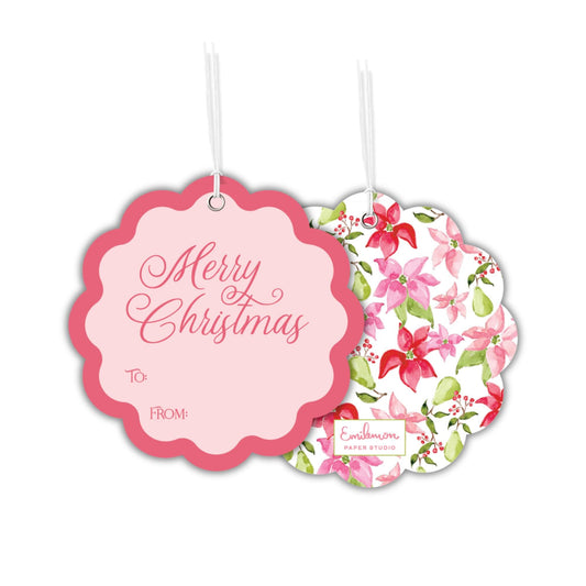 two pink scalloped tags with Christmas-themed designs hanging from strings.