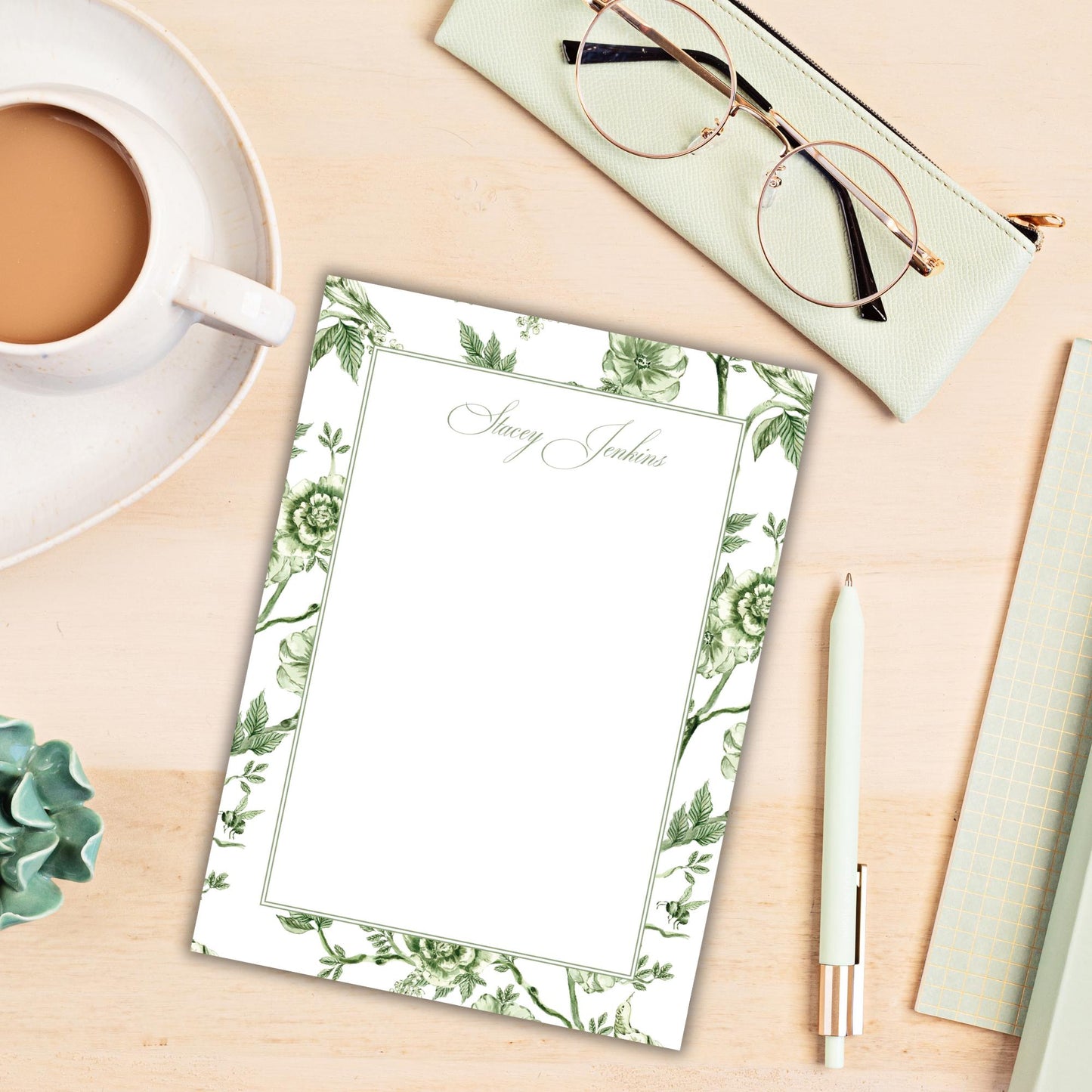 a cup of coffee and a notepad on a desk