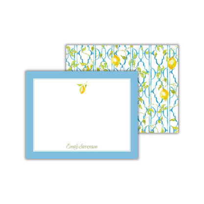 a blue-framed note card with a blank space for writing a message, and a patterned background with a repeating design of yellow lemons and green leaves.