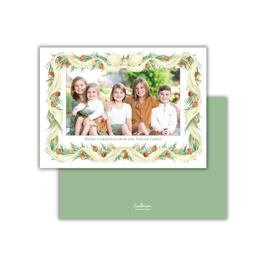 A family portrait of five children, likely siblings, sitting together in a festive frame with a wreath design.