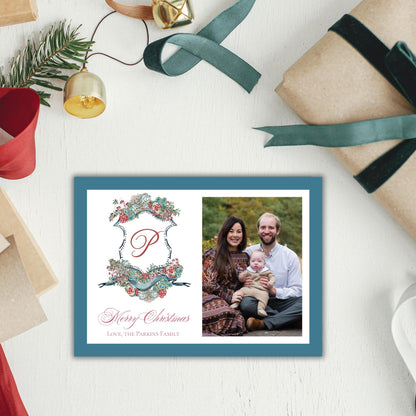 A holiday-themed card with a family photo and a decorative shield design, surrounded by Christmas decorations and gifts.