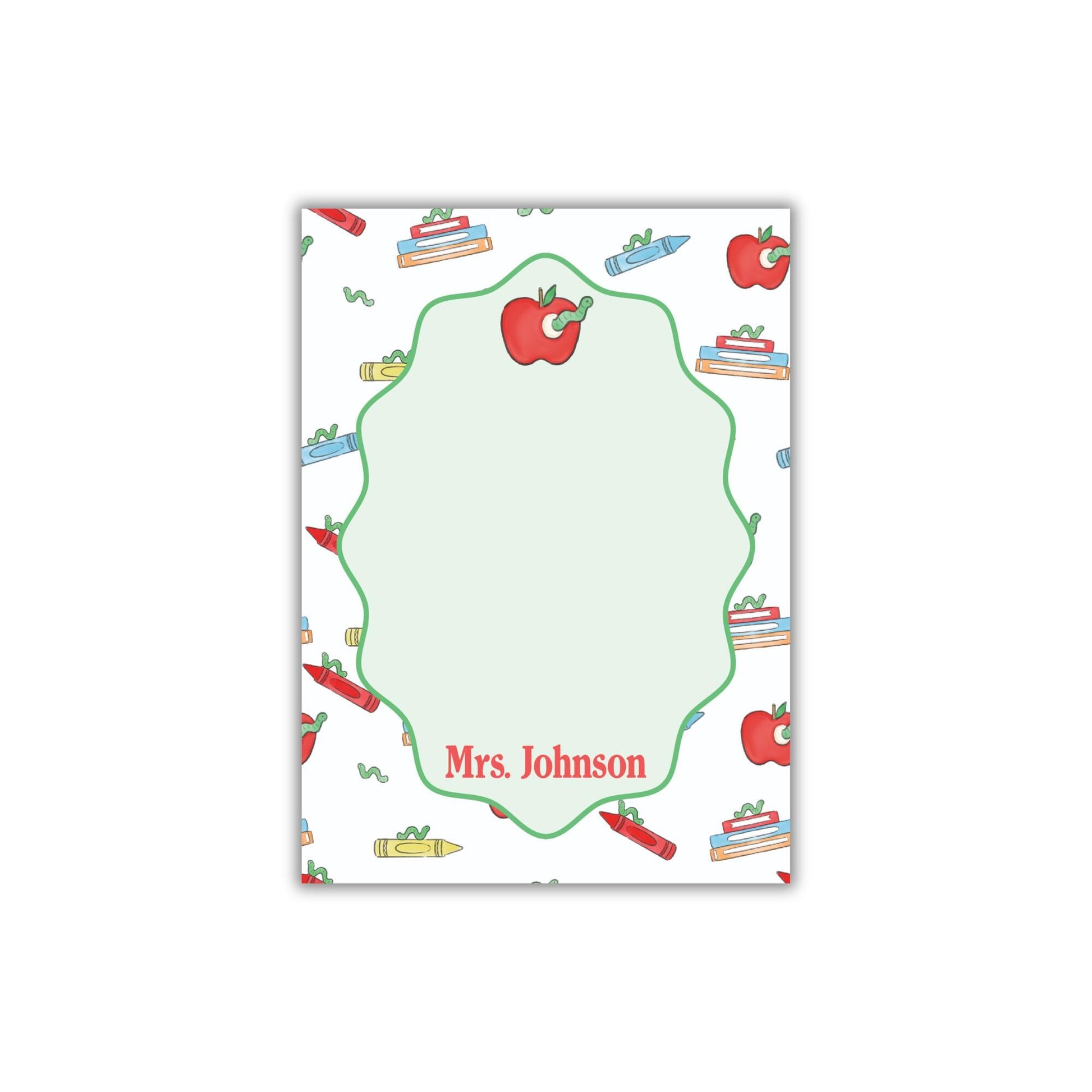 The image is a personalized nameplate with a repeating pattern of apples, crayons, and books. The nameplate has a green border and the name "Mrs. Johnson" written on it.