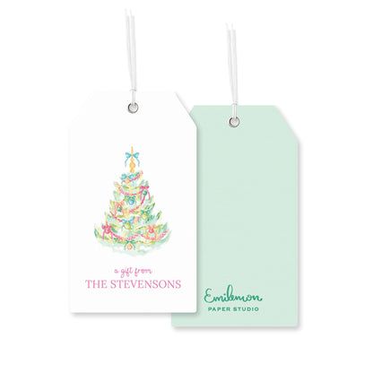 two tags, one white and one green, with a Christmas tree design on them. The white tag reads "a gift from THE STEVENSONS" and the green tag reads "Emilmon PAPER STUDIO".