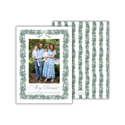 A family portrait of a man, woman, and child, with a floral border around the photo frame. The text on the card reads "Merry Christmas" and "Santa, Linda, and Grace Weatherby".